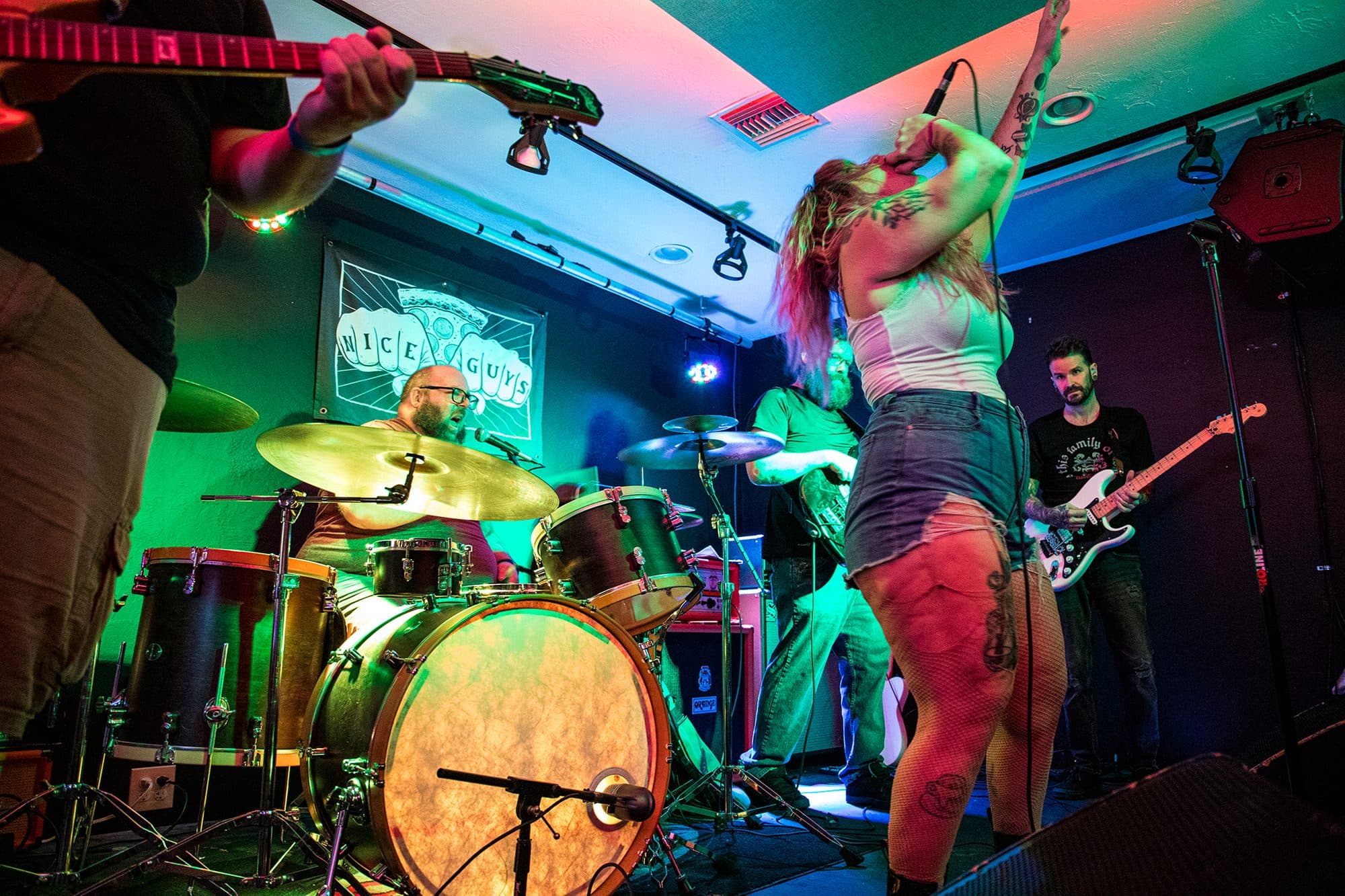 Drummer and singer under green and blue lights