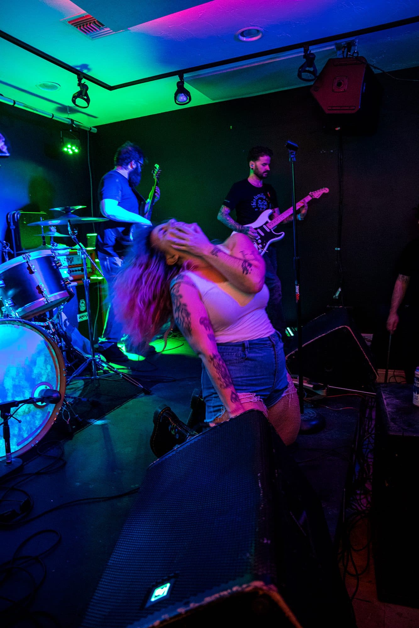 A singer mid hair-flip under blue light