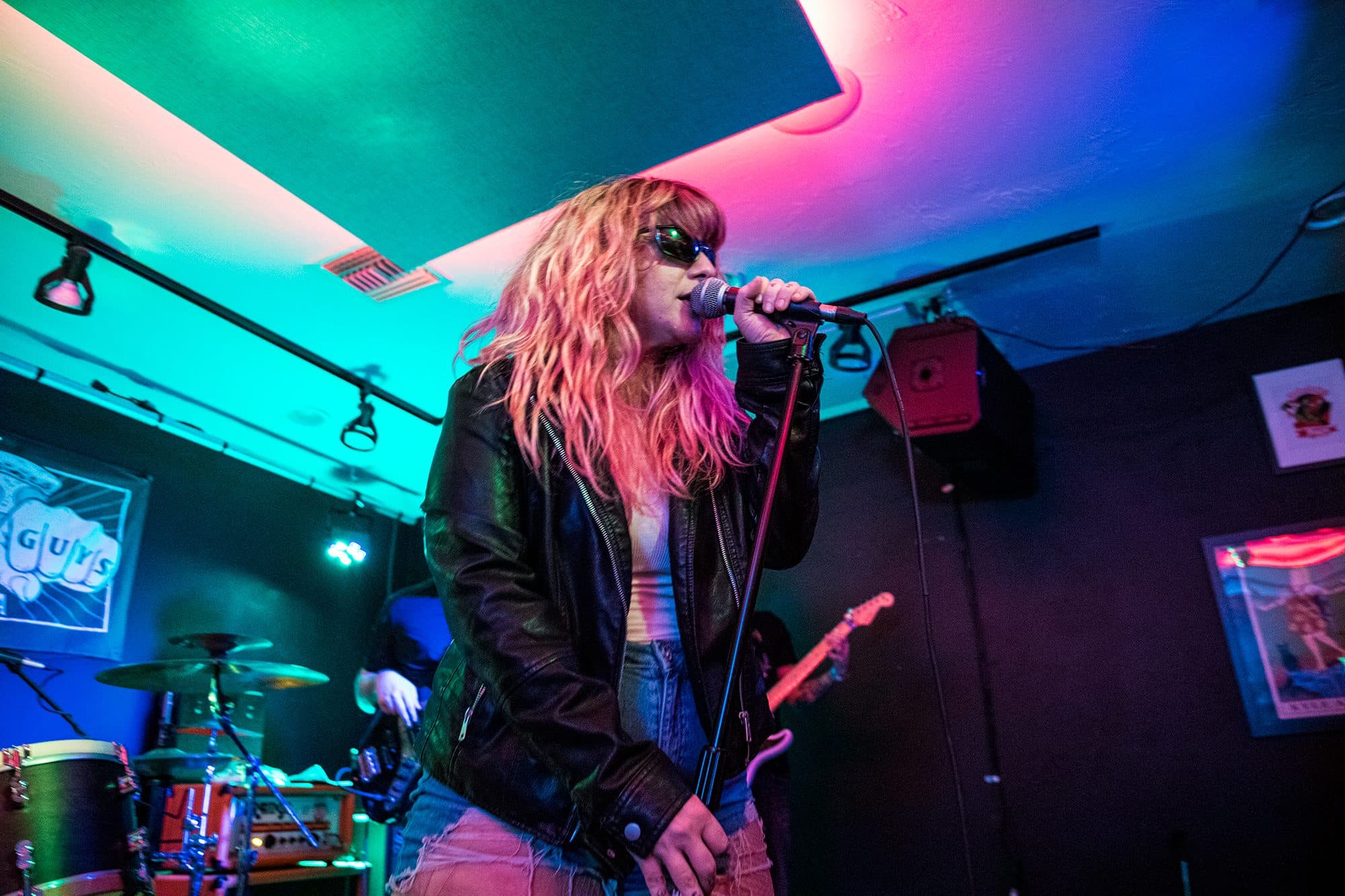A singer in a leather jacket under red light