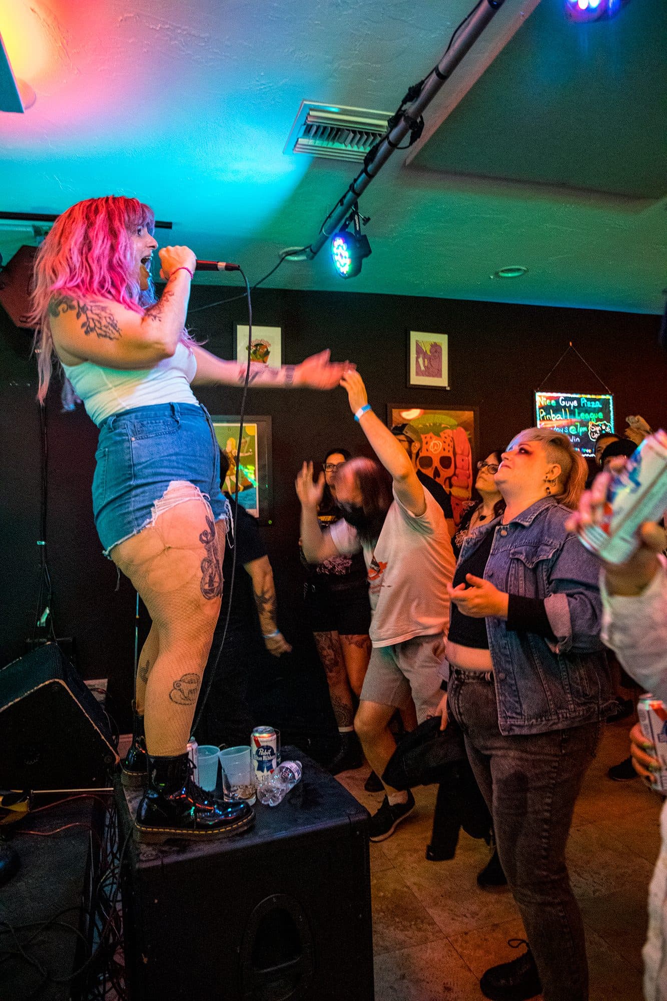 A singer standing on an amp, singing down into the crowd