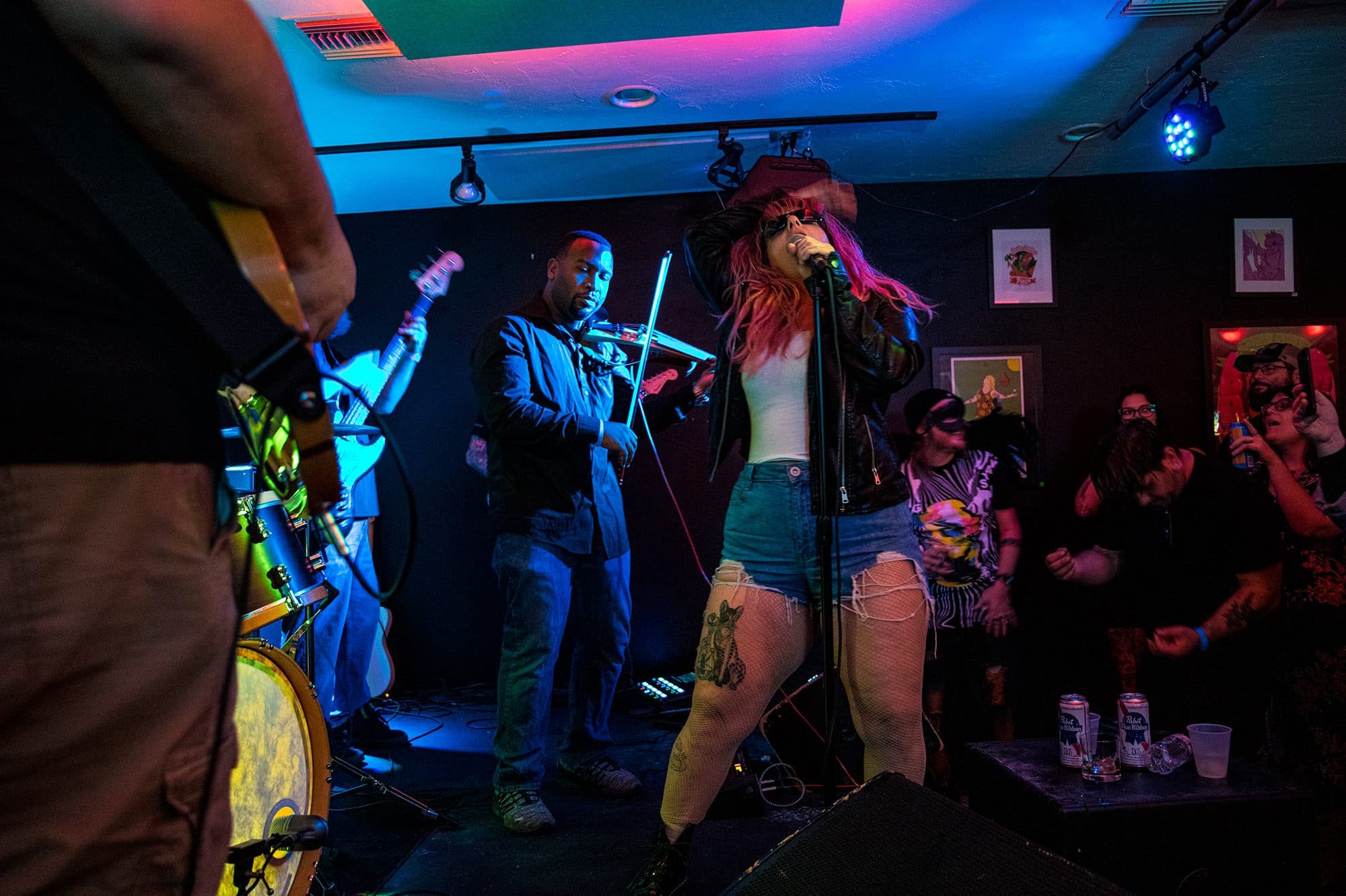 A violinist and singer playing to a packed room