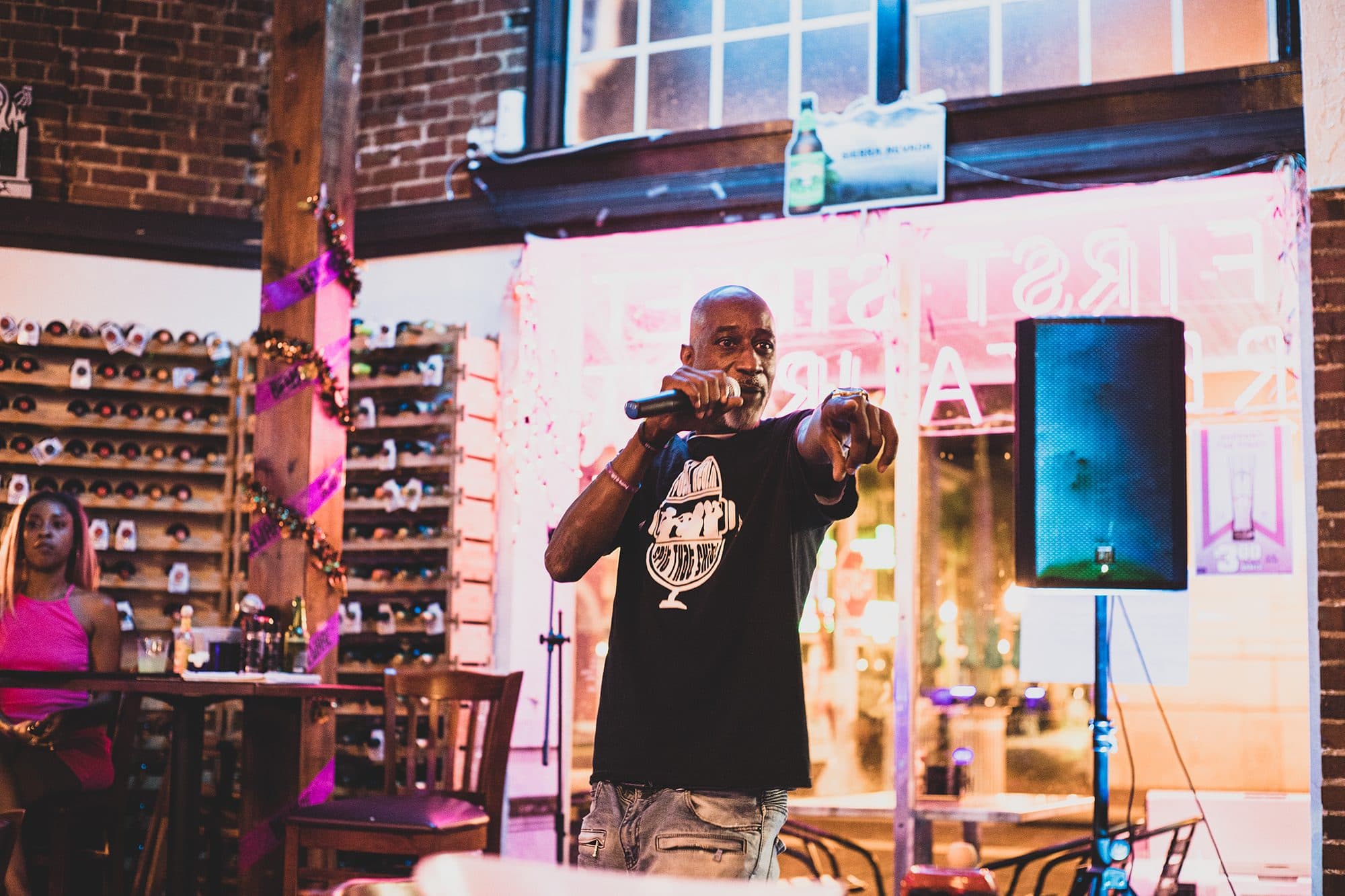 An MC on the mic in a brick-walled restaurant